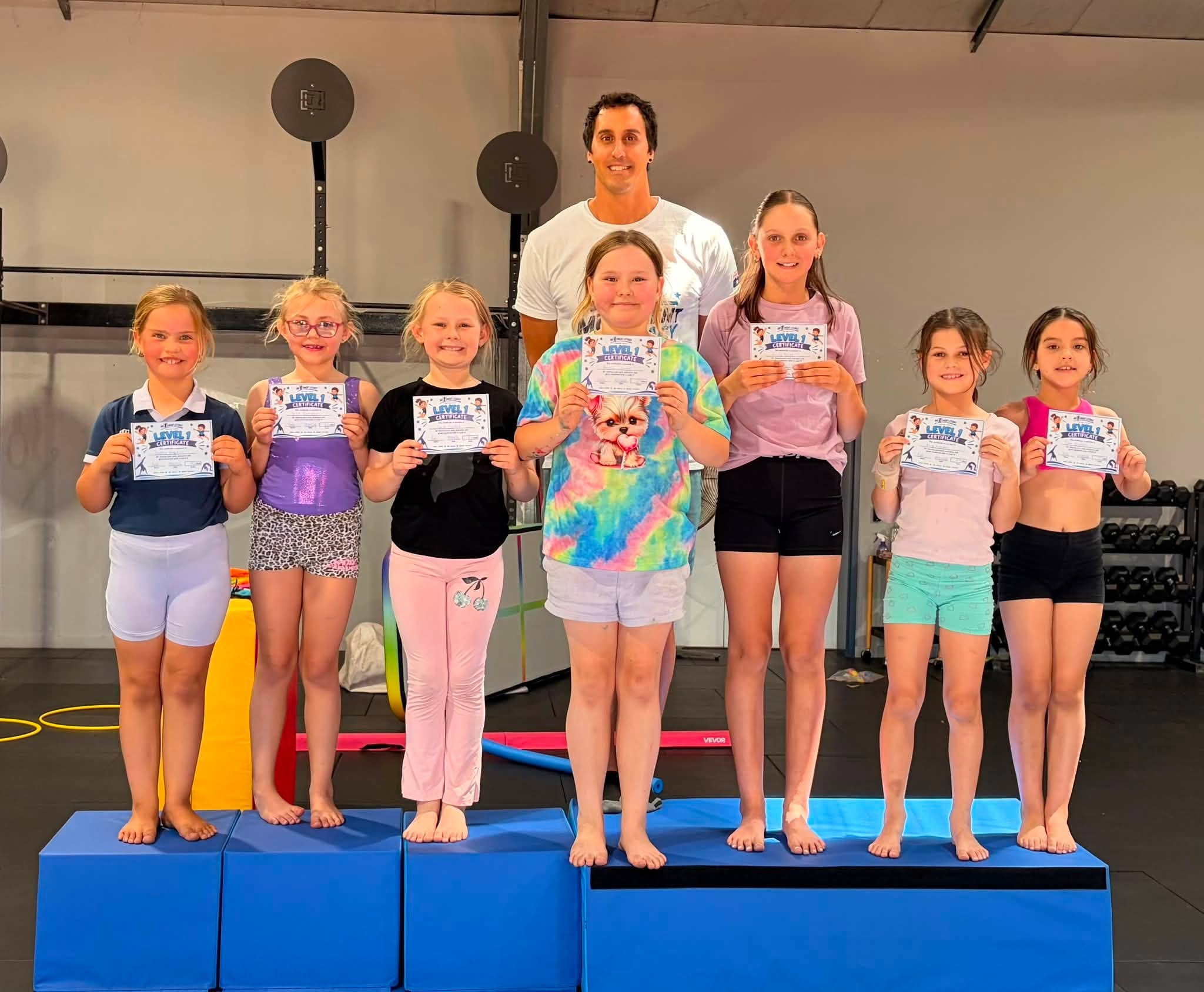 Level 1 students with certificates and Coach Gabriel